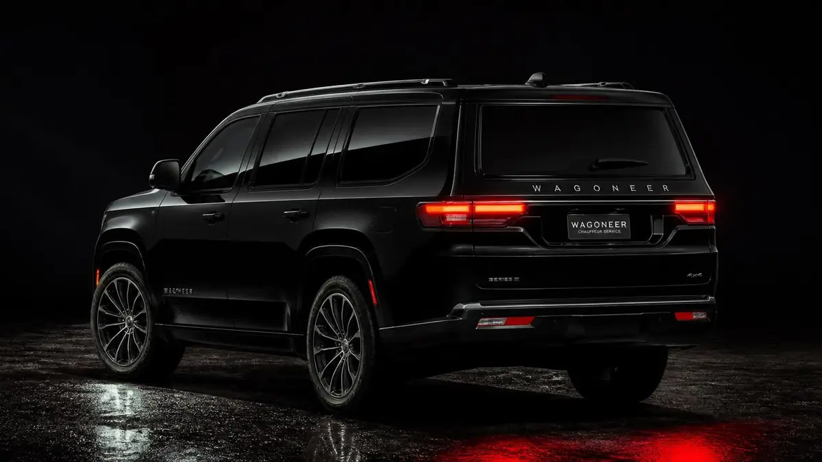 Black Jeep Wagoneer seen from the rear at night with its red taillights on