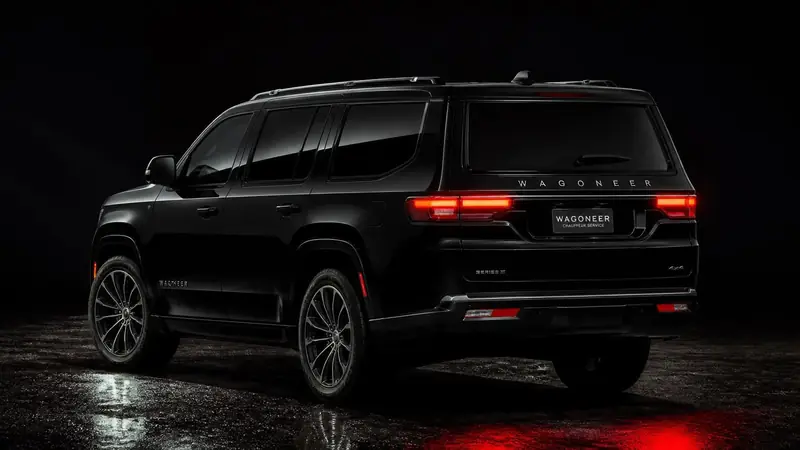 Black Jeep Wagoneer seen from the rear at night with its red taillights on